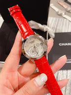 Chanel watch with bright red leather strap and silver floral butterfly dial