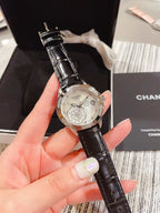 Chanel watch with black leather strap and silver floral butterfly dial