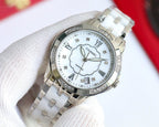 Silver Chanel watch with white dial, clover motif, Roman numerals, polished metal bracelet.