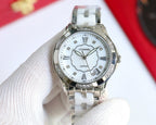 Silver Chanel watch with white dial, clover motif, Roman numerals, polished metal bracelet.