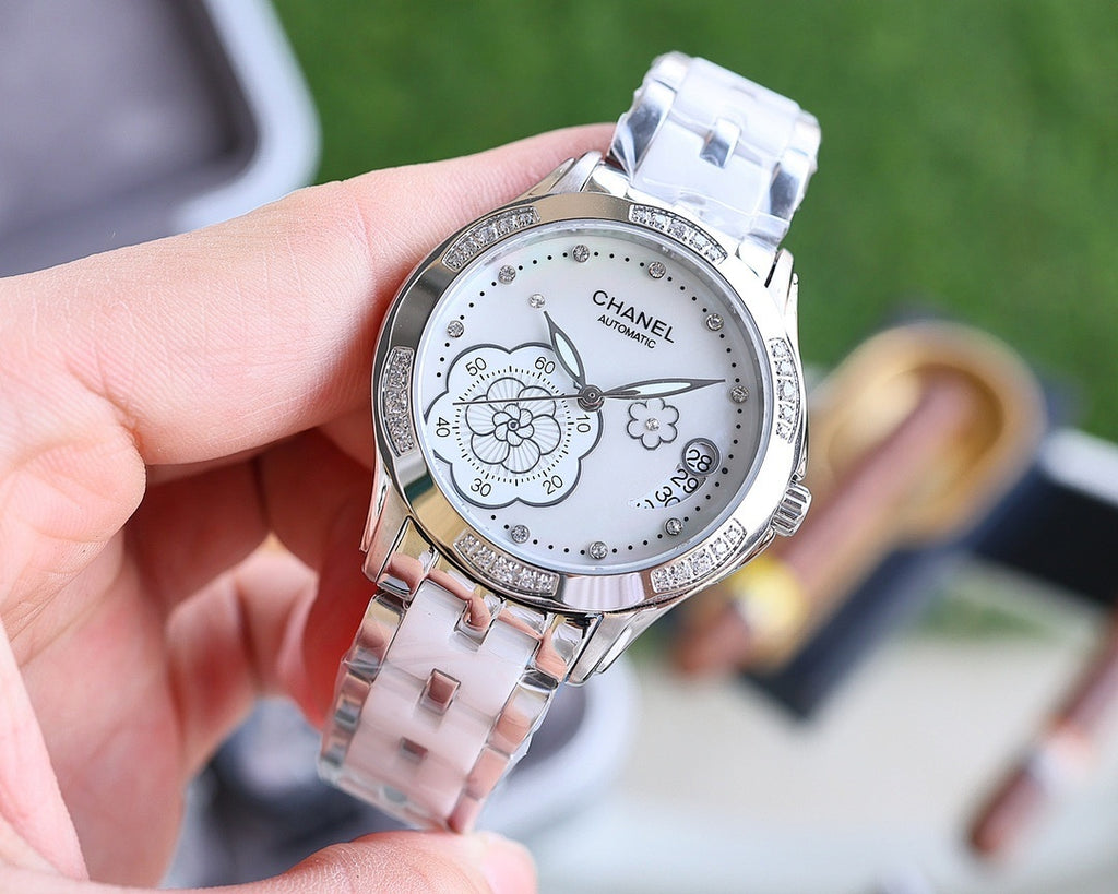 Analog Chanel watch with silver bracelet and white dial, diamond accents and flowers