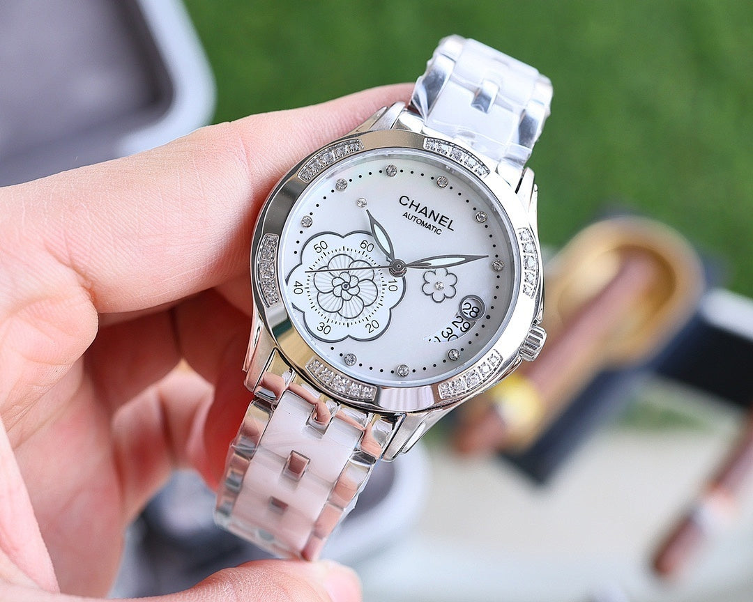 Analog Chanel watch with silver bracelet and white dial, diamond accents and flowers