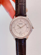 Wristwatch with white dial, crystal-look bezel, and dark brown leather strap