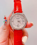 Wristwatch with white dial, crystal-look bezel, and bright red leather strap