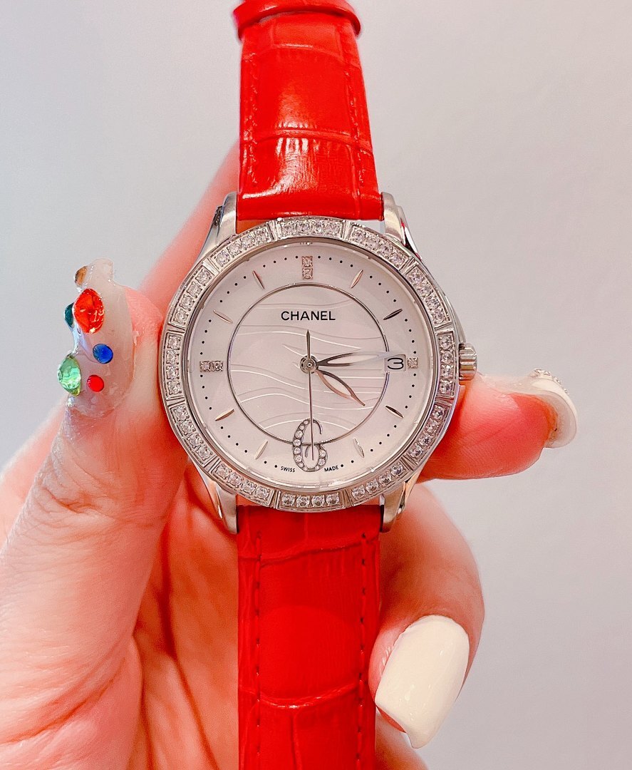 Wristwatch with white dial, crystal-look bezel, and bright red leather strap