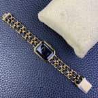 Gold-tone rectangular watch with navy blue bracelet links and dark dial, Chanel logo