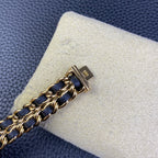 Gold-tone clasp and chain links of a navy blue watch bracelet