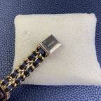 Gold-tone clasp on a navy blue and gold chain watch bracelet, Chanel emblem