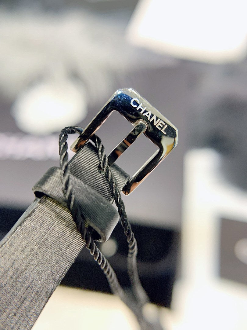 Chanel watch clasp with black leather strap and engraved gold-tone buckle