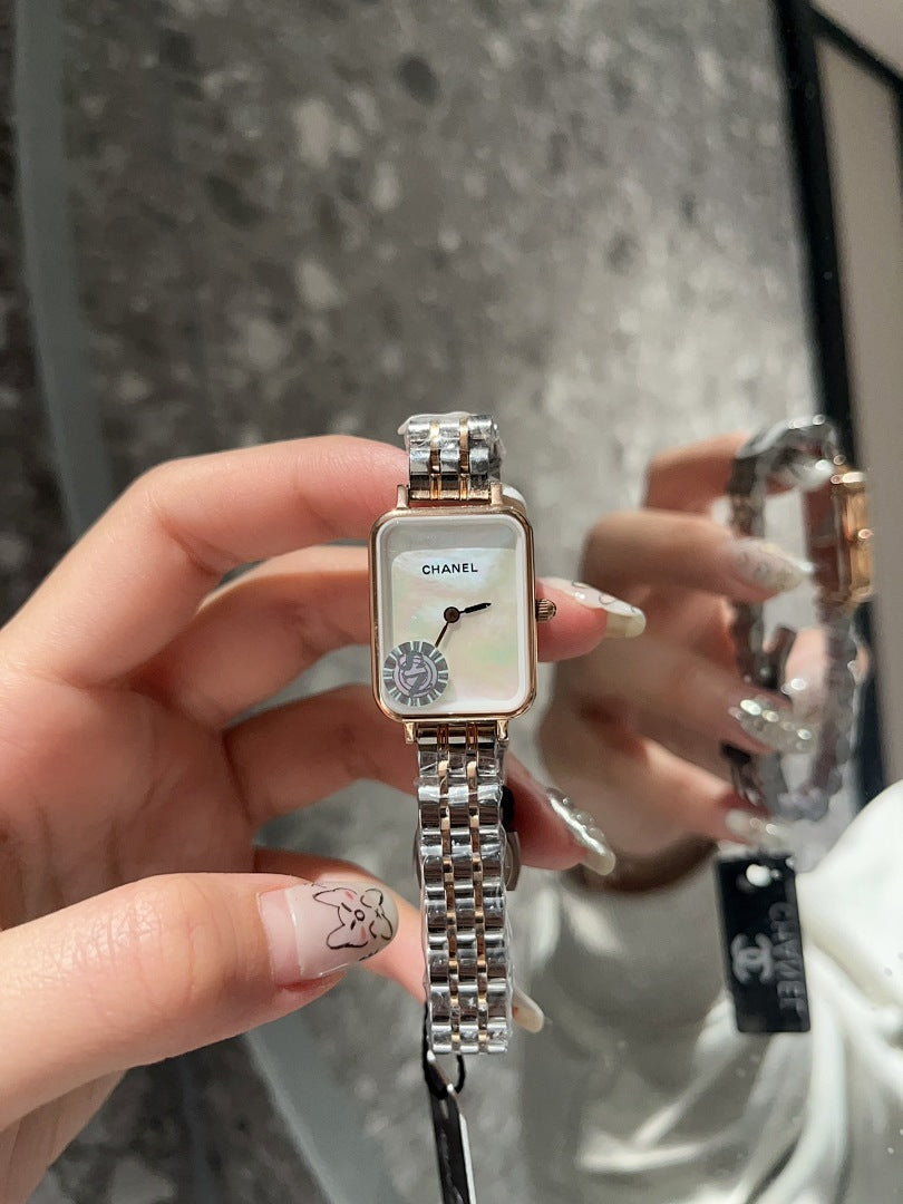 Rectangular CHANEL wristwatch with silver-tone link bracelet and white dial held up