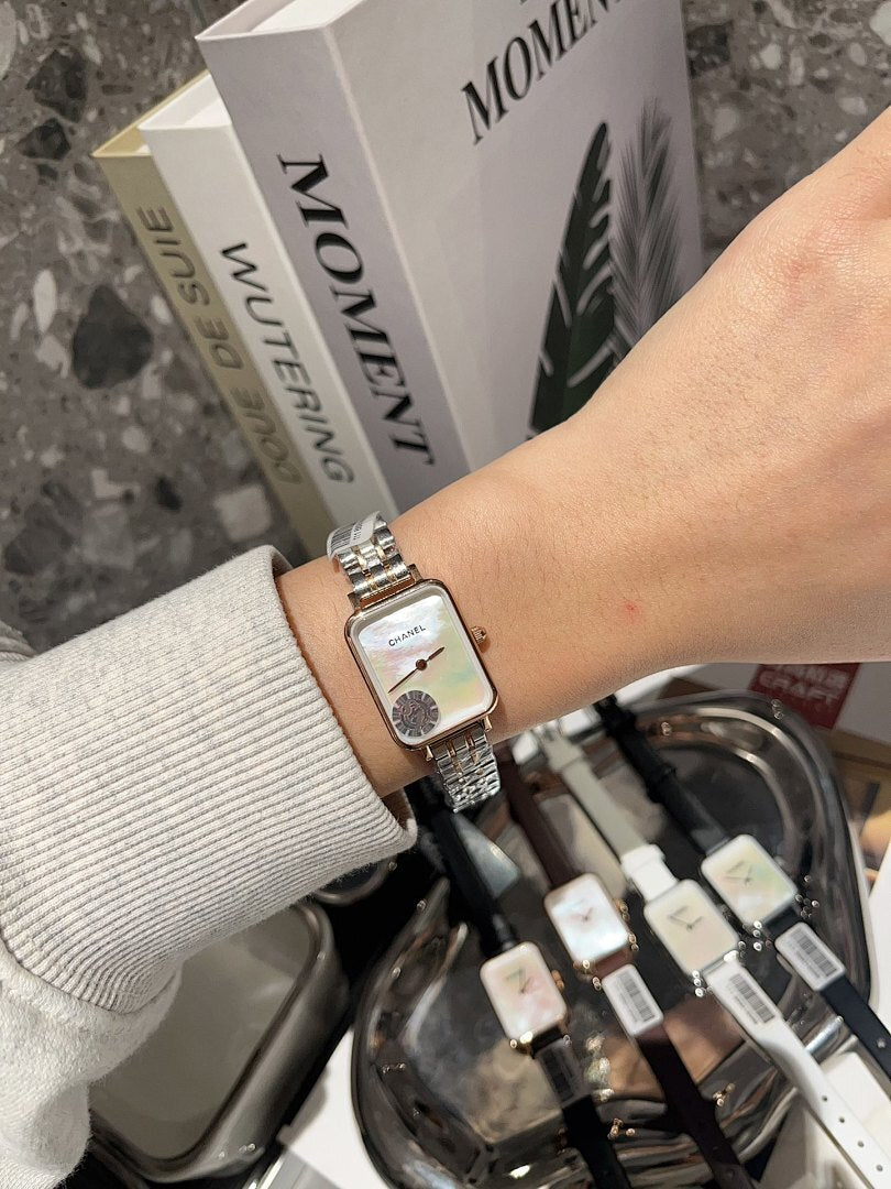 Rectangular wristwatch with silver-tone metal bracelet and white dial with round motif