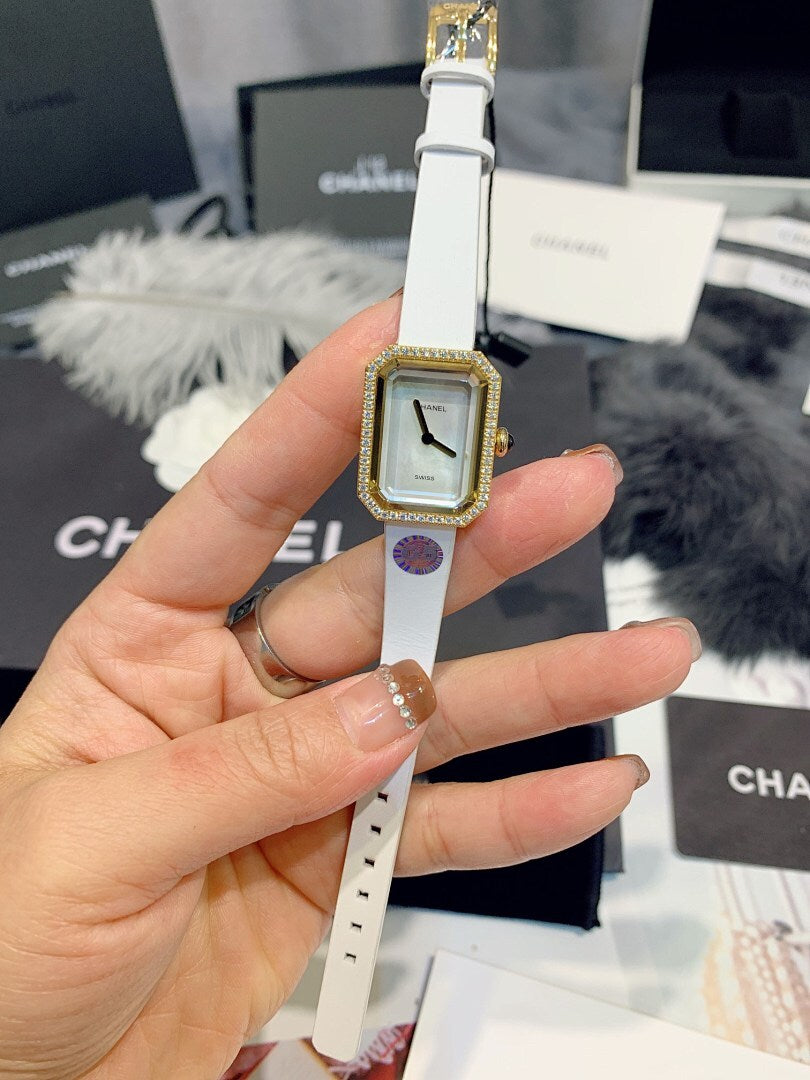 Chanel rectangular-dial watch with white strap and gold-toned bezel