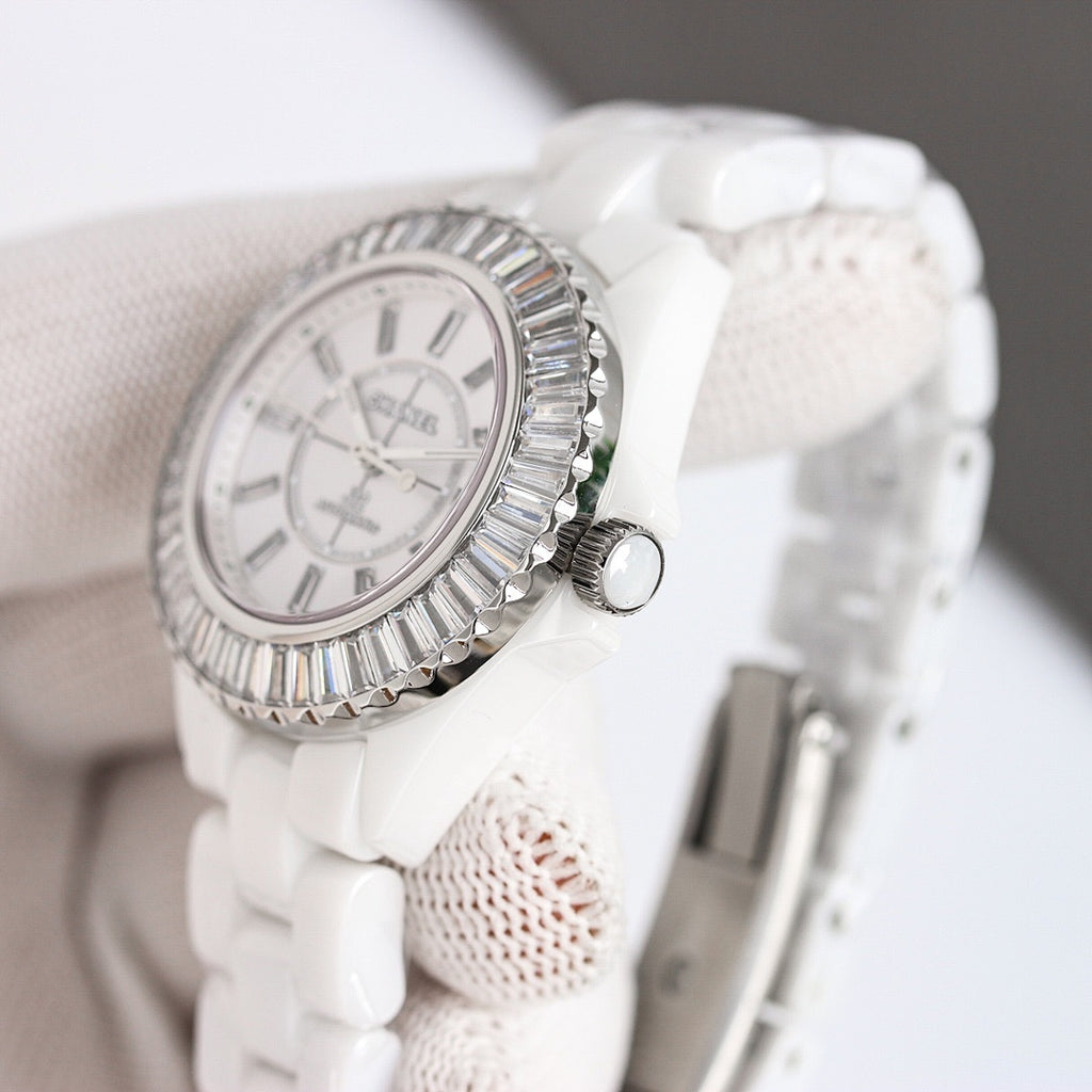 Chanel watch with silver-tone bezel and white dial, white ceramic strap, side view.