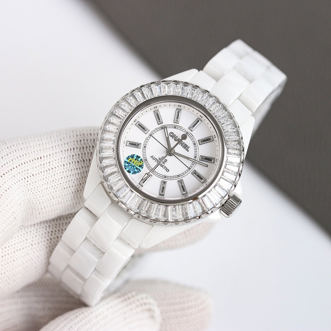 Chanel watch with white ceramic strap, silver-tone jeweled bezel, round white dial view.
