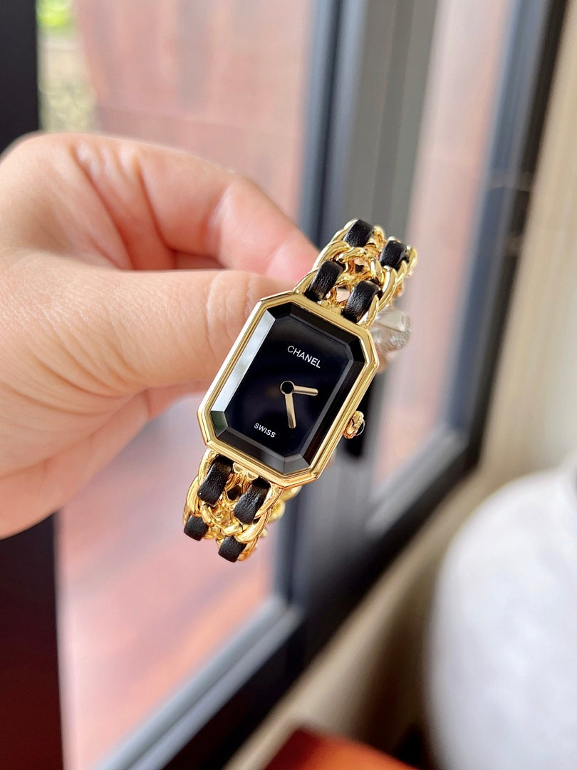Chanel watch with black dial and gold-tone linked bracelet, side view