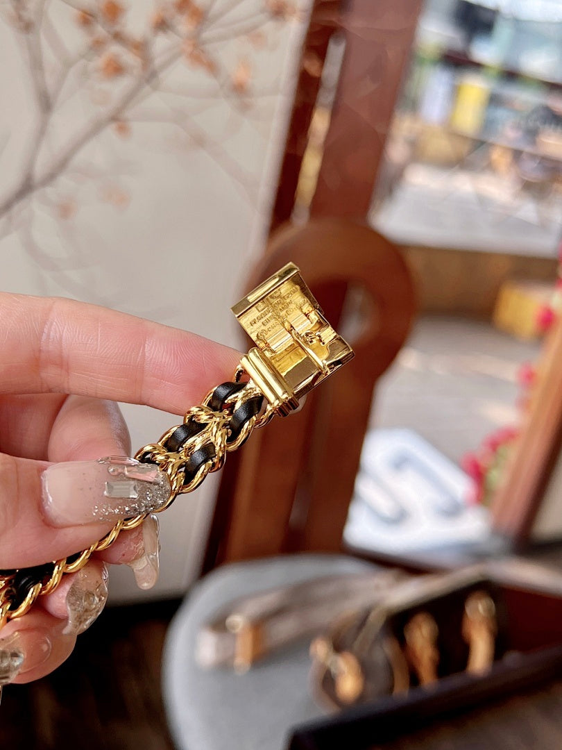 Chanel watch clasp and gold-tone link bracelet detail on a hand