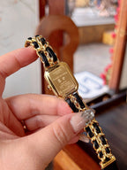 Chanel watch on gold-tone bracelet with black face and gold hands