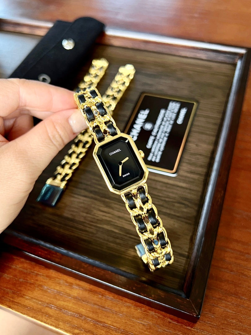Chanel watch on gold-tone linked bracelet with black dial and gold hands