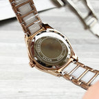 Chanel watch caseback with engraved text, rose-gold bezel, white metal bracelet