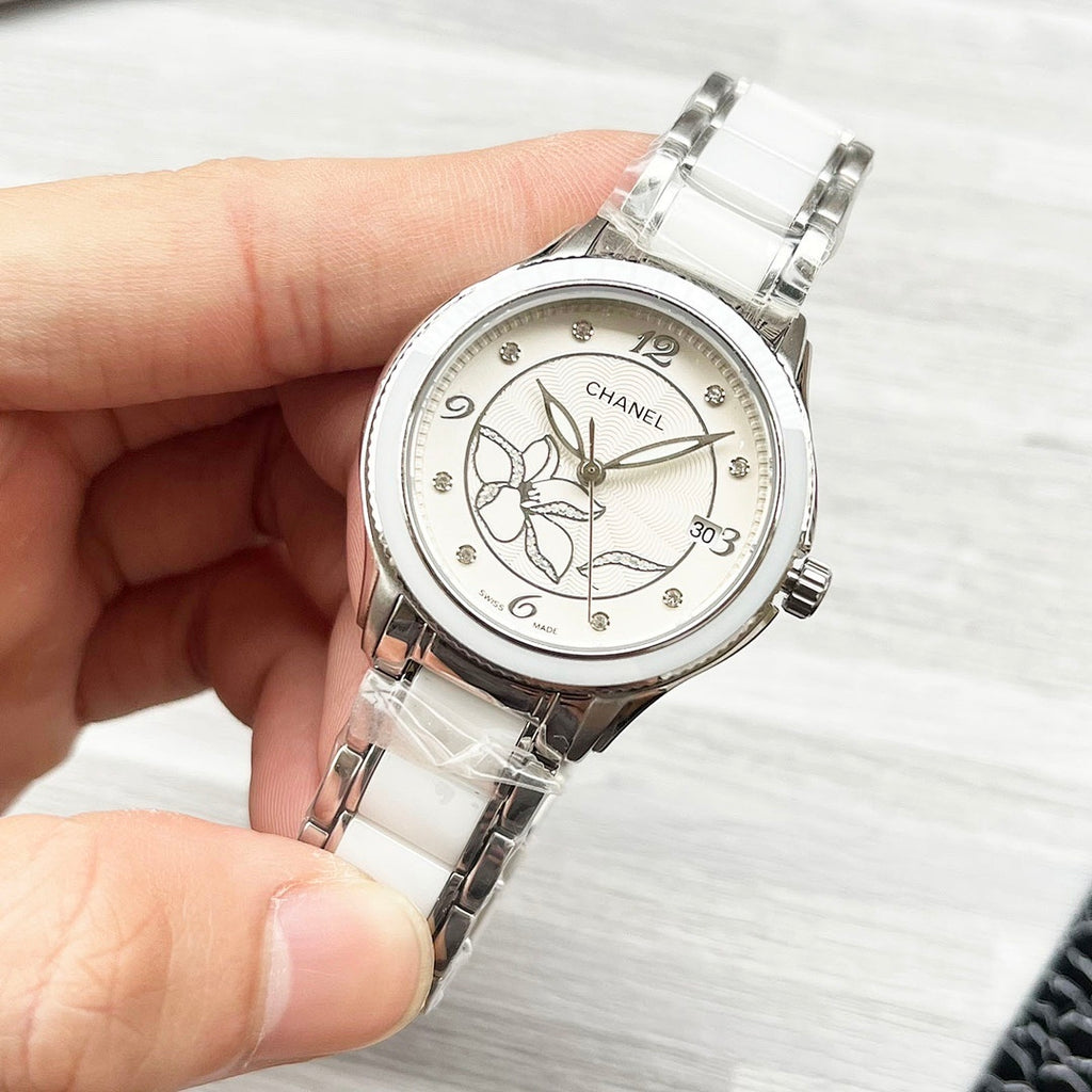 Chanel watch with white metal bracelet and silver-tone floral dial, close-up