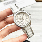 Chanel watch with white metal bracelet and silver-tone floral dial, front view