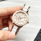 Chanel watch with rose-gold case, white metal bracelet, and floral dial close-up