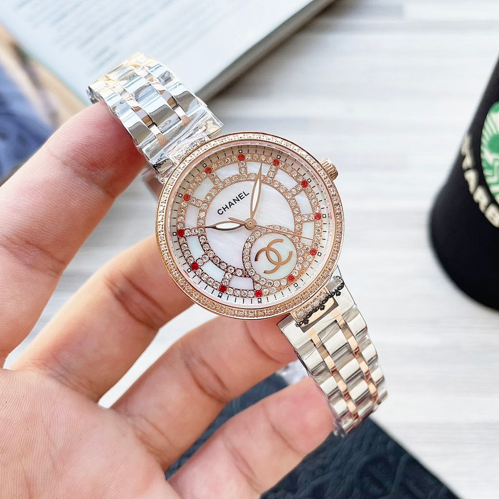 Chanel watch with crystal bezel, white dial, red-accent details, two-tone metal bracelet