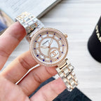 Chanel watch with crystal bezel, rose gold-tone case, white dial, blue accents, two-tone band