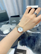 Chanel wristwatch on hand with silver metal bracelet and pale dial