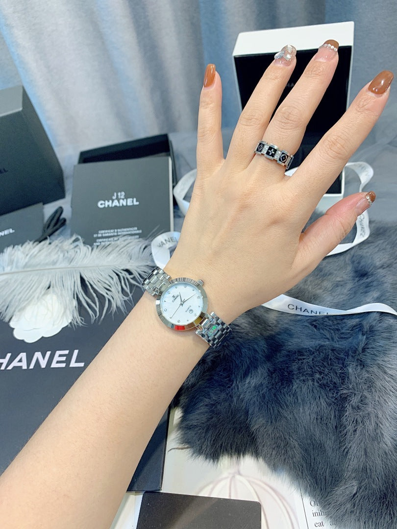 Chanel wristwatch on hand with round dial and silver metal bracelet