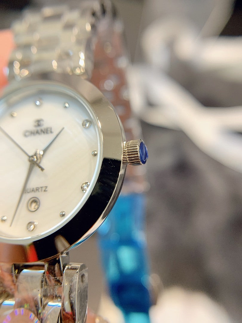 Chanel quartz wristwatch close-up with light dial, crown, and silver bracelet