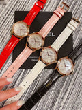 Chanel watch with red leather strap, round gold-tone case and floral dial
