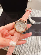 Chanel watch with pink leather strap, gold-tone case and floral dial, held in hand