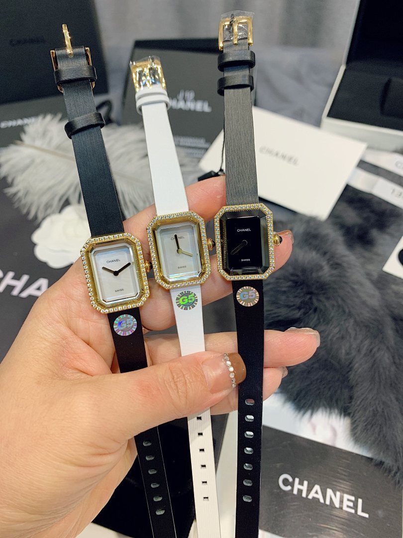 Four square-faced wristwatches with black and white leather straps and gold-tone cases