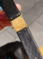 Chanel watch close-up with black textured leather strap and gold-tone case