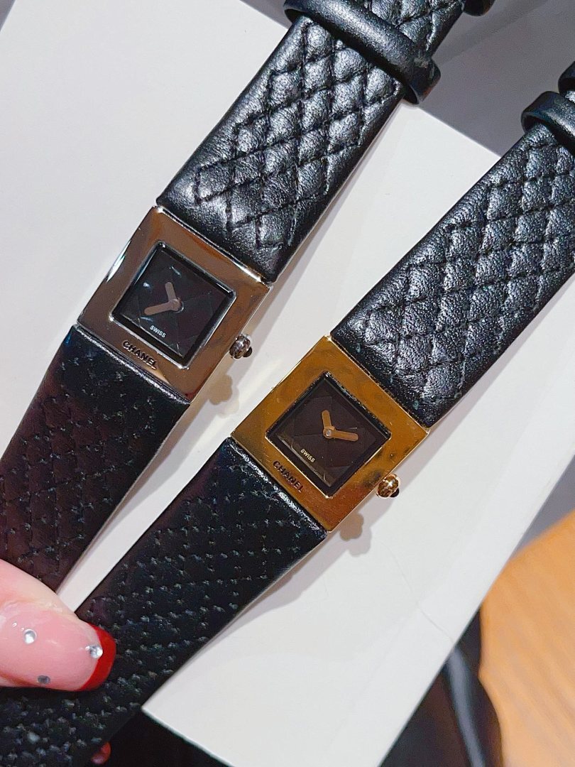 Two Chanel watches with black leather straps and gold-tone square dials
