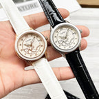Two Chanel watches with floral cream dials; white leather strap and black leather strap.