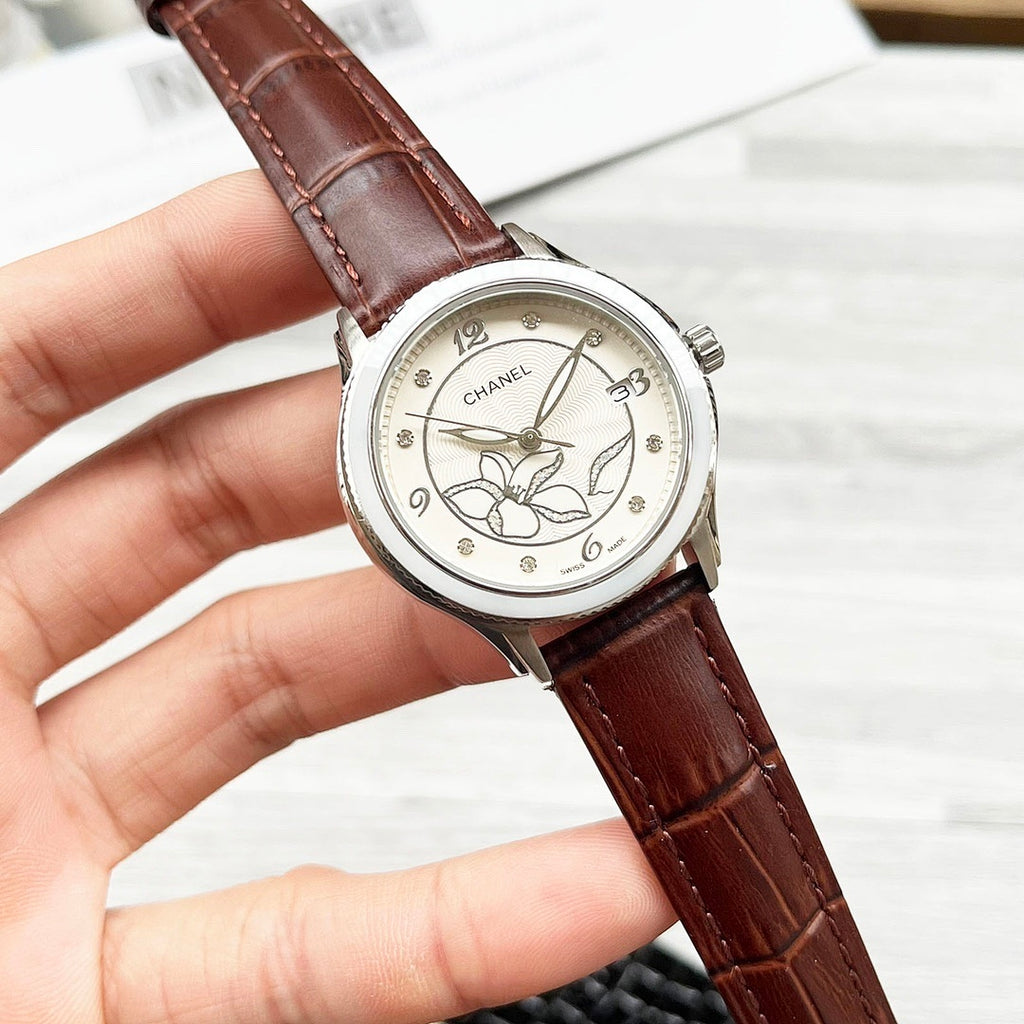 Chanel wristwatch with floral cream dial and dark brown leather strap.