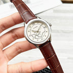Chanel wristwatch with floral cream dial and dark brown leather strap.
