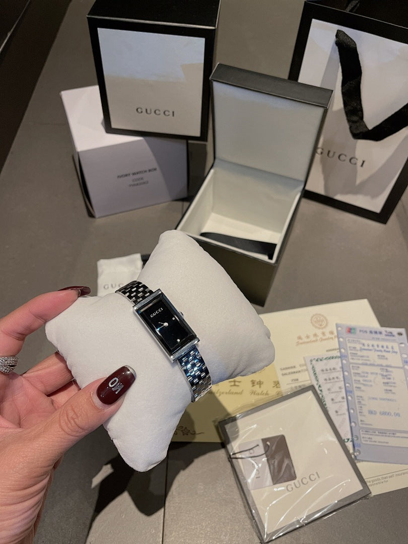 Chanel wristwatch with silver link bracelet on white cushion, black dial
