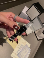 Chanel wristwatch close-up in hand, silver link bracelet and black dial