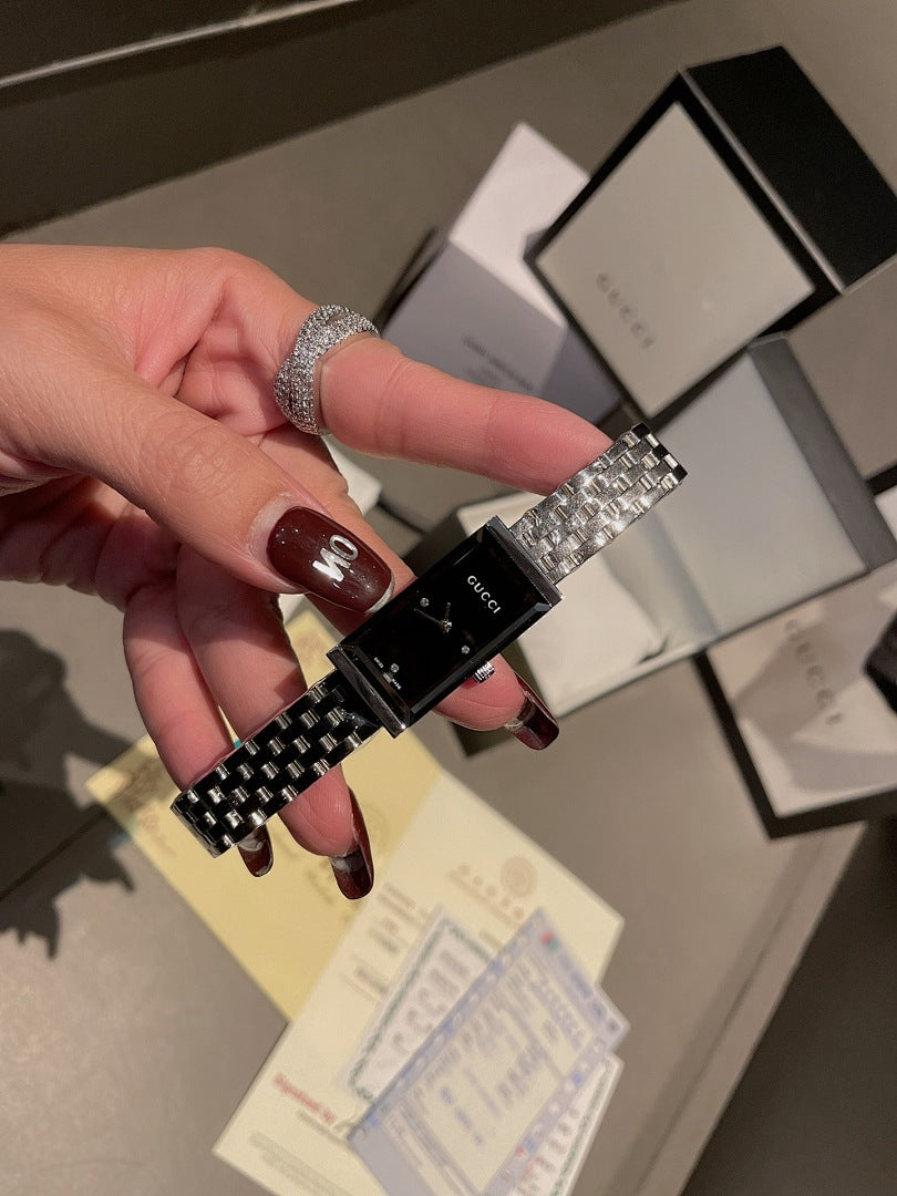 Chanel wristwatch close-up in hand, silver link bracelet and black dial