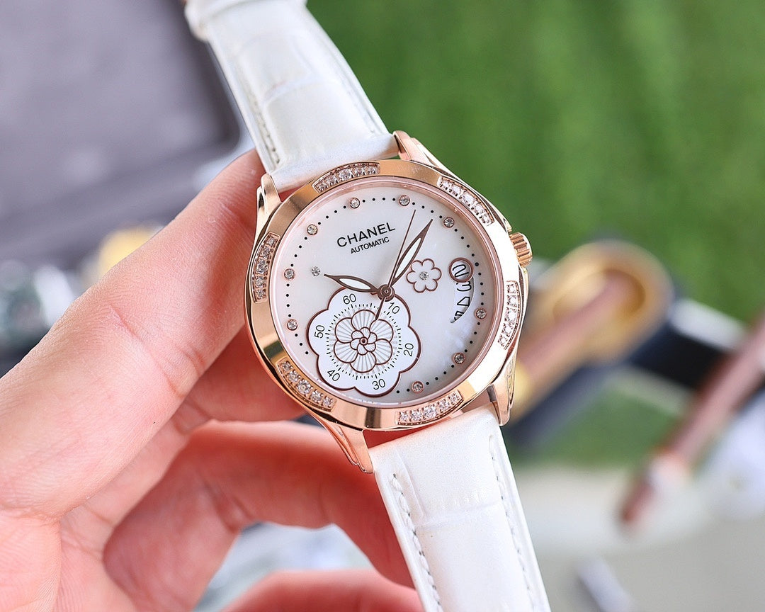 Chanel watch with white leather strap, rose-gold case and round white dial with floral motifs