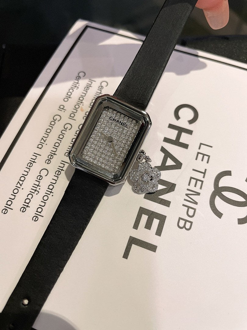 Chanel square silver-tone watch with black leather strap, textured dial and charm