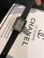 Chanel square silver-tone watch with black leather strap, textured dial and charm