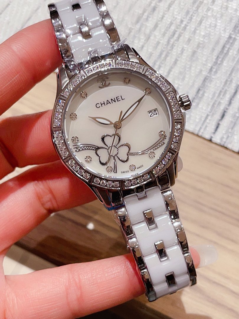 Chanel wristwatch with a white floral dial, diamond-look bezel, and silver metal link band.
