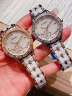 Pair of Chanel wristwatches in rose gold and silver tones, jeweled bezels with white floral dials.