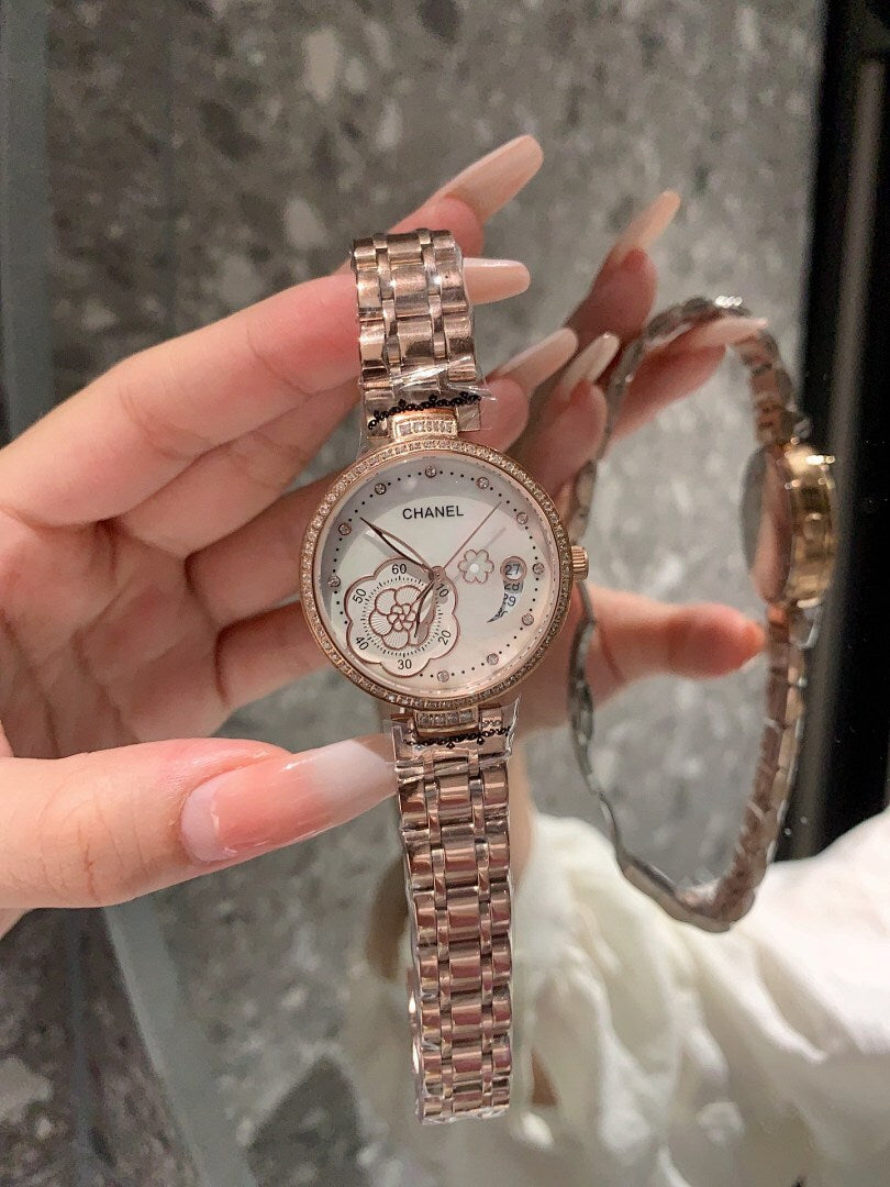 Chanel wristwatch with round silver-tone dial and linked metal bracelet, held by hand