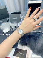 Chanel watch on wrist, round silver dial with metal link bracelet
