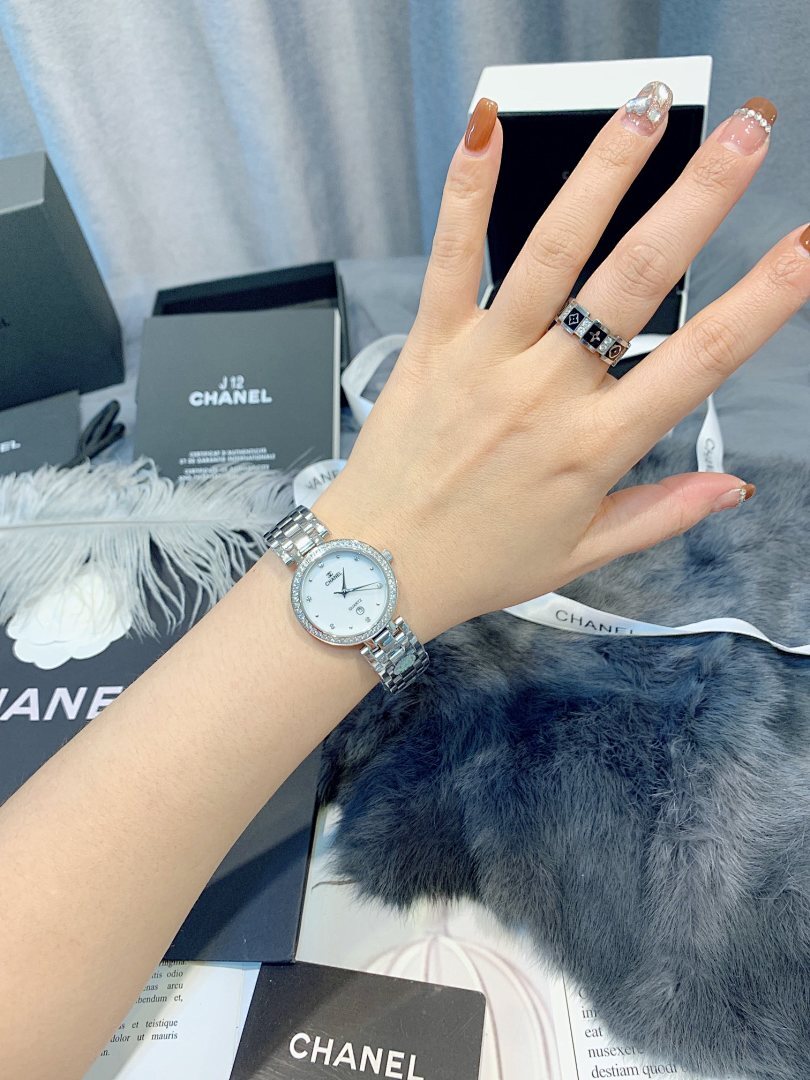 Chanel watch on wrist, round silver dial with metal link bracelet
